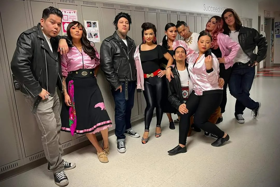 The cast of Bear Grease, dressed in 1950s costumes, poses in front of high school lockers