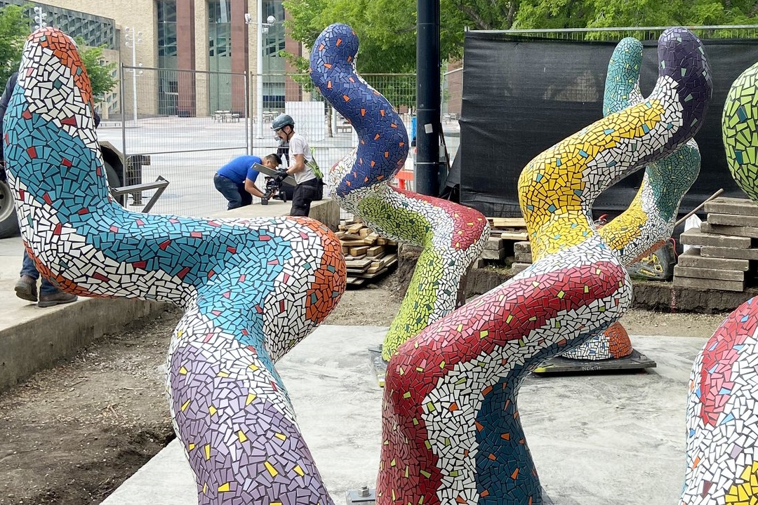 Five large, tentacle-like sculptures covered in colourful tiles undulate towards the sky
