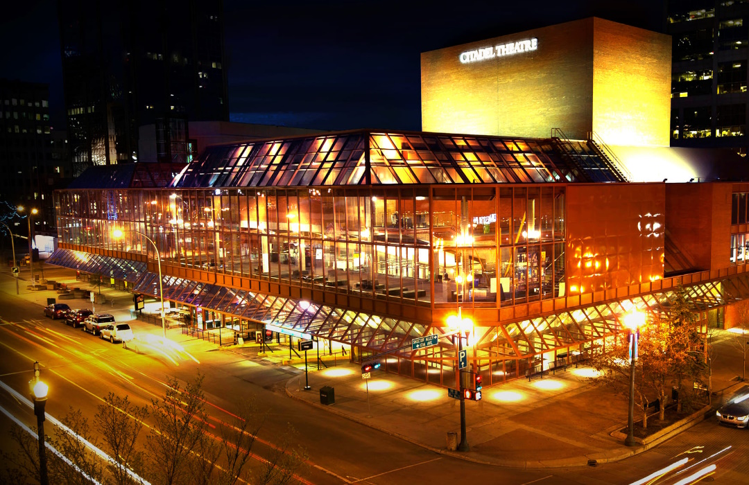 An aerial view of the Citadel Theatre lit up at night.