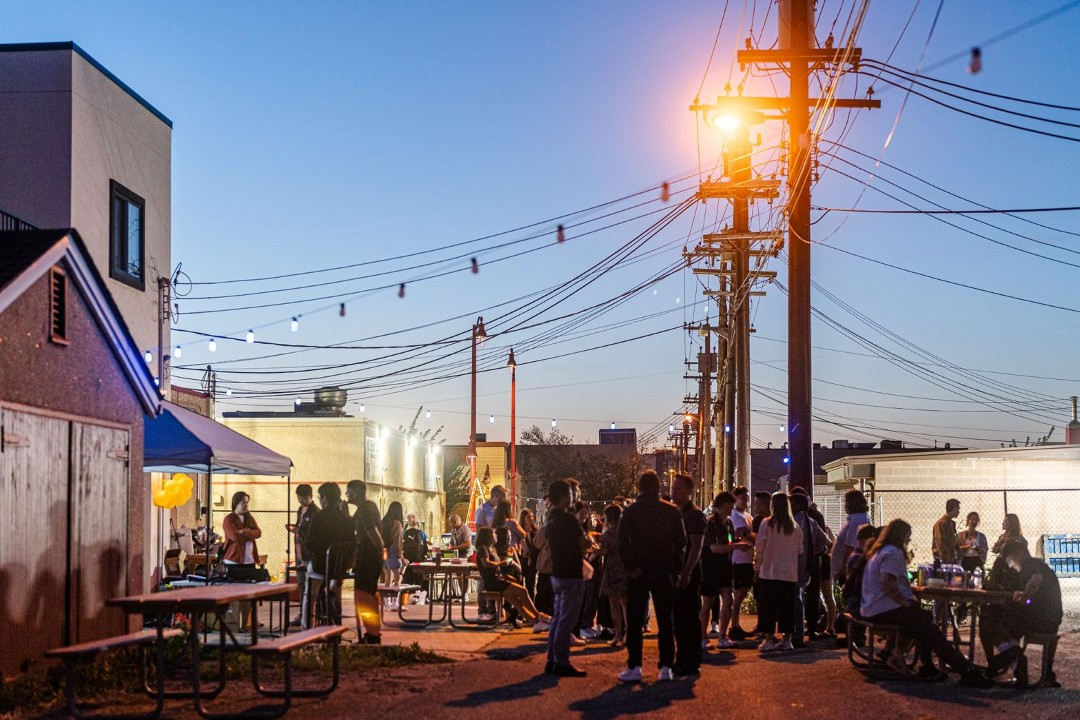 A crowd gathers in an alley behind the China Marble Restaurant in Edmonton's Chinatown as the sun goes down.