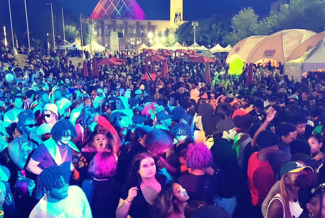 A large crowd of people is gathered at Churchill Square for Cariwest Festival.