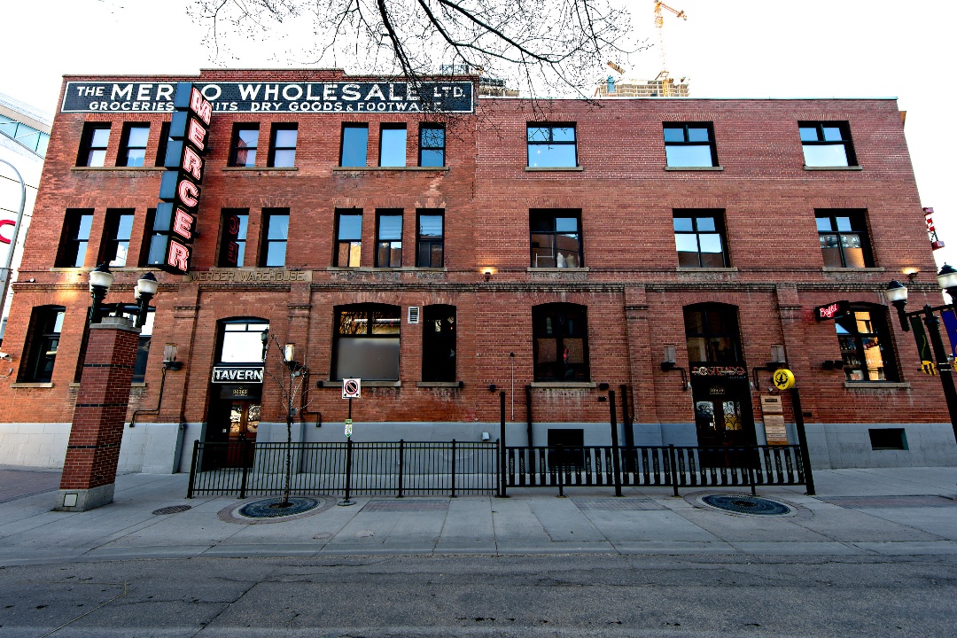 A brick warehouse with a neon sign reading 