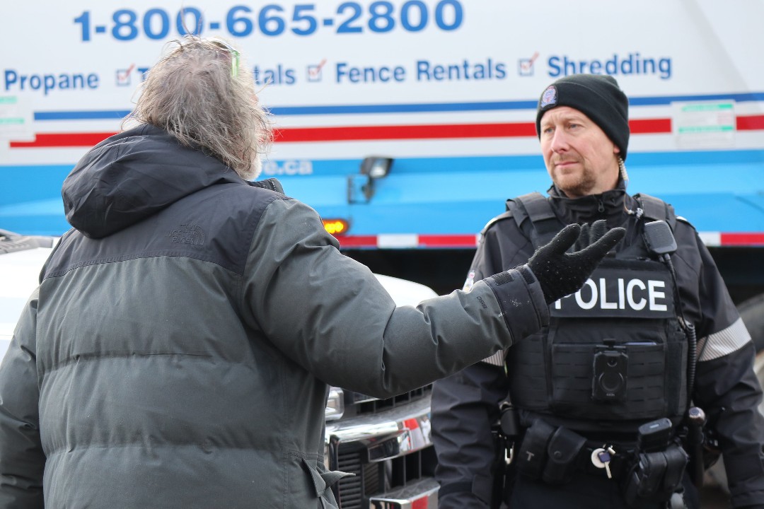 A person speaks with a police officer at an encampment eviction