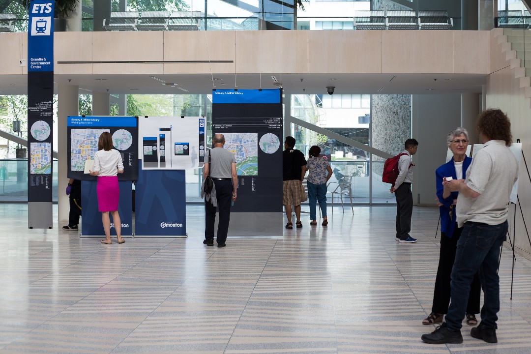 A file picture from 2016 of the interior of Edmonton city hall, where people look at displays during a public engagement session.