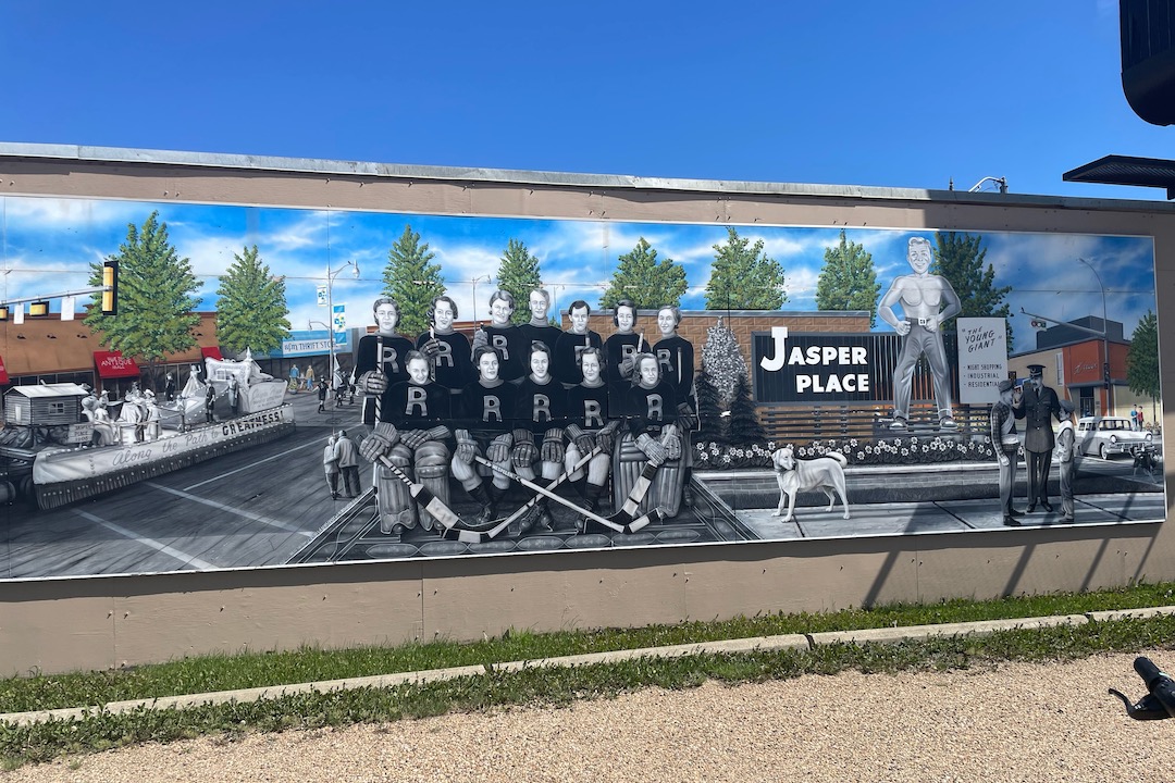 A mural depicts young hockey players in a streetscape within Jasper Place.