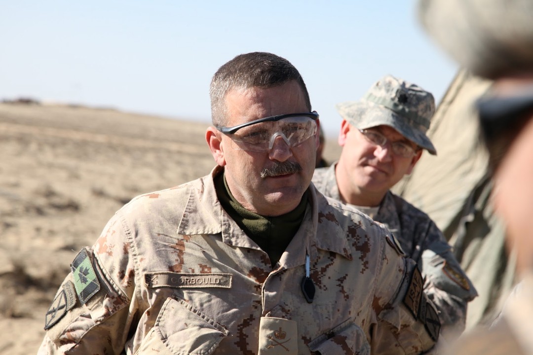 Former city manager Andre Corbould dressed in army fatigues in the desert sands of Afghanistan