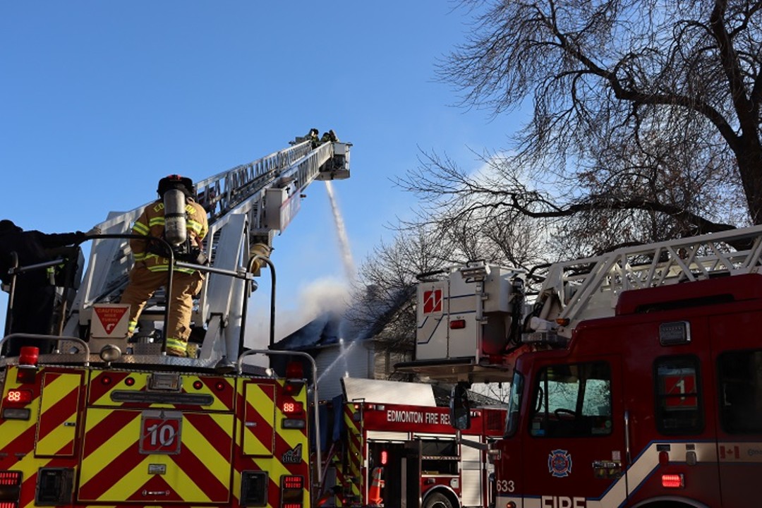 Edmonton firefighters spray water on a fire.