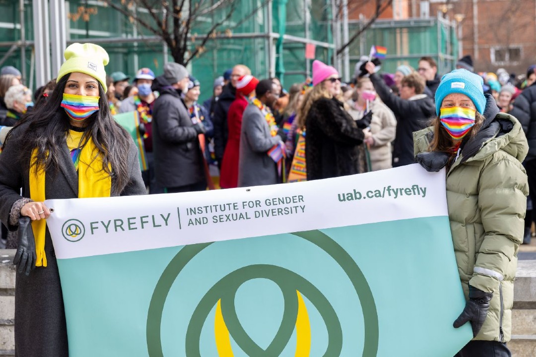 Two people hold a sign for the Fyrefly Institute.