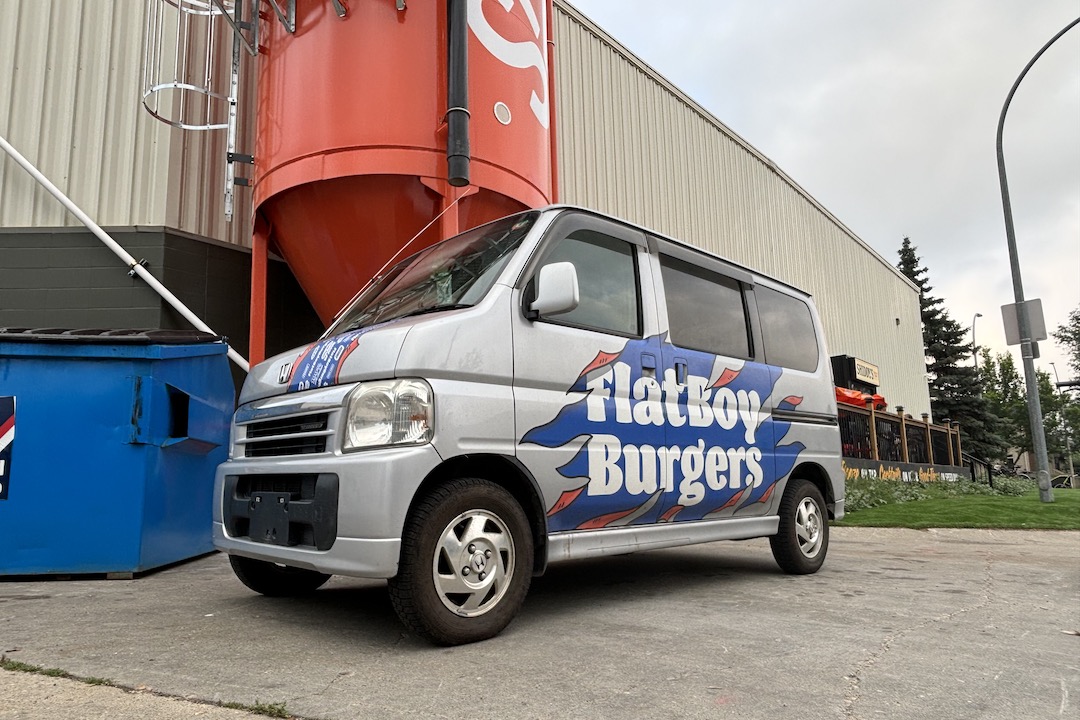 A photo of a small van that has been branded for Flat Boy Burgers