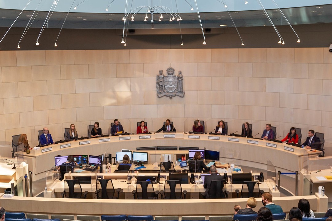 A photograph of all 12 of Edmonton's city councillors and the mayor in the council chambers at City Hall