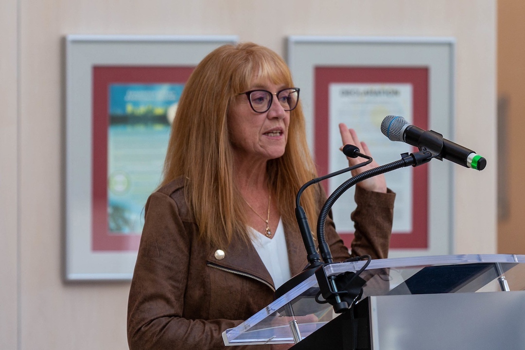 A woman stands at a podium