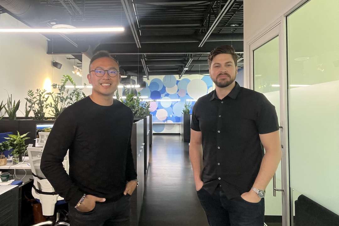 Two people pose in an office.