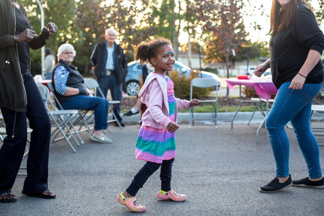 A child with face paint at a community league event.