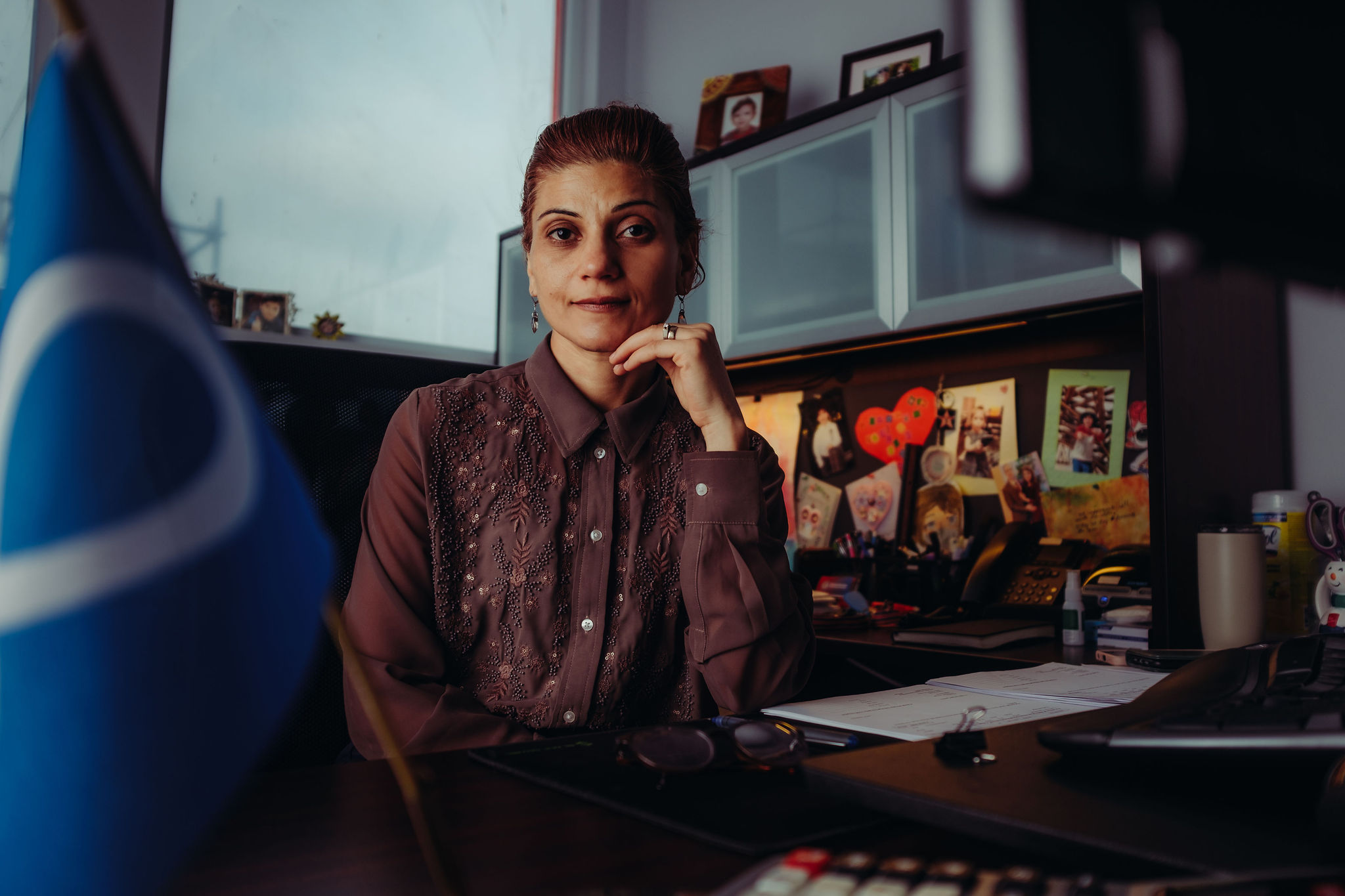 A woman sits behind a desk.