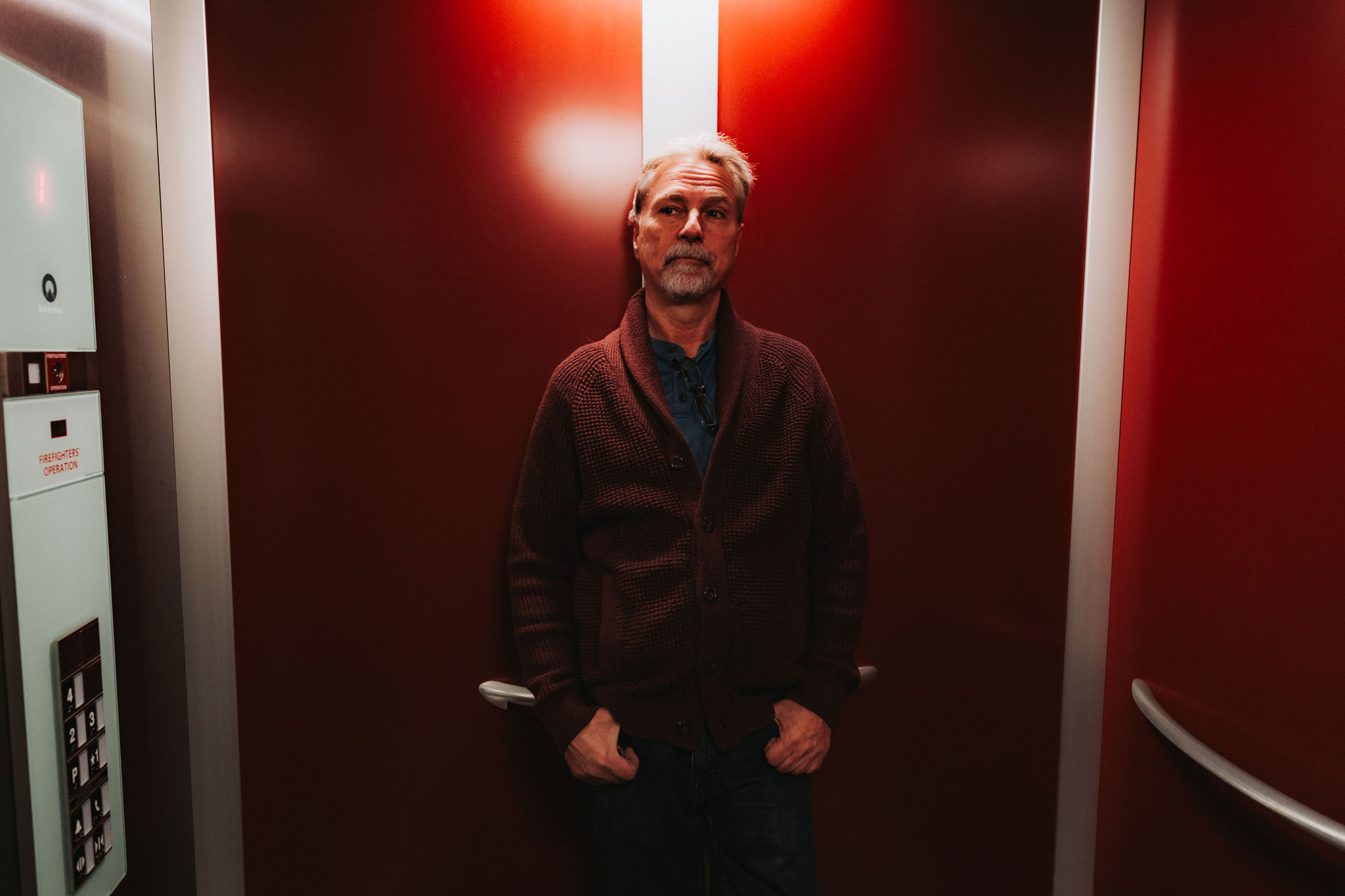 A man stands in an elevator.