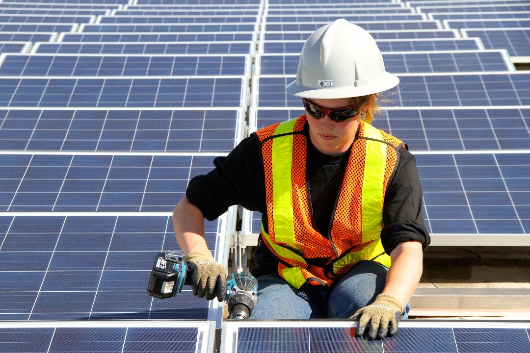 A photo of a worker installing solar panels in the Ottewell neighbourhood of Edmonton