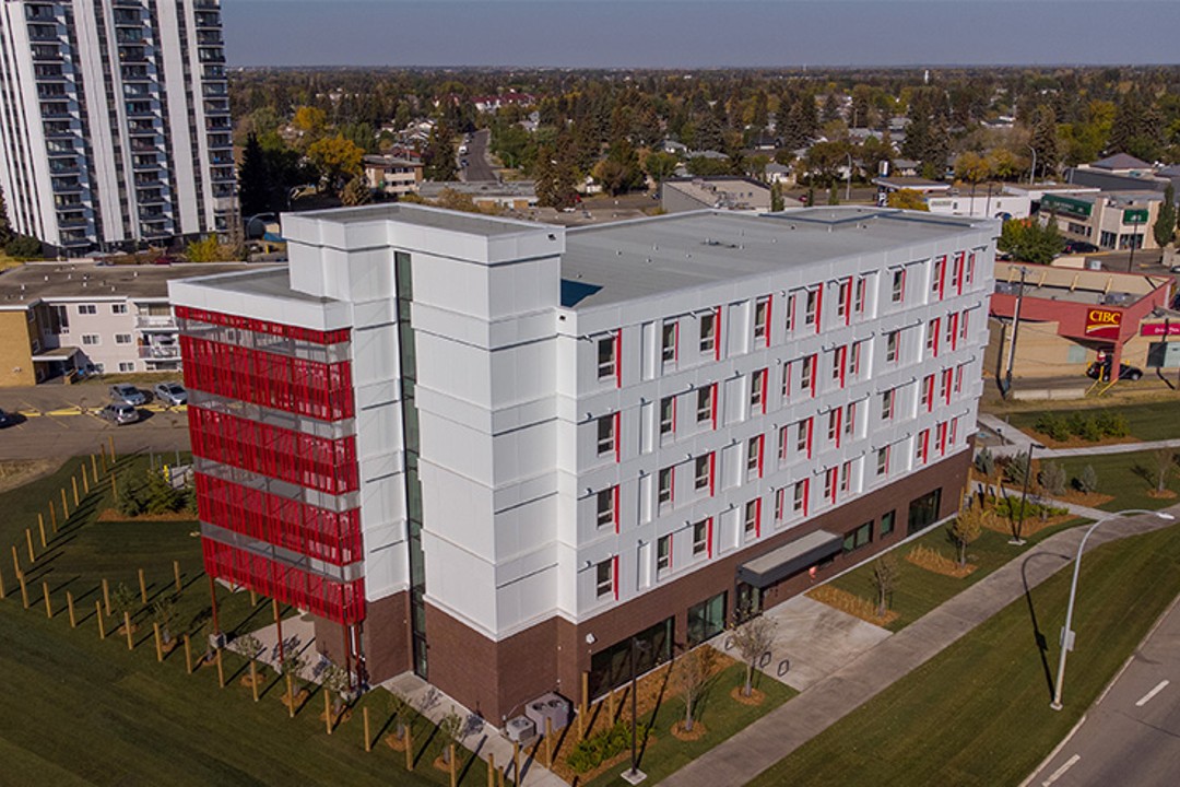 A red and white five-storey multifamily residential building.