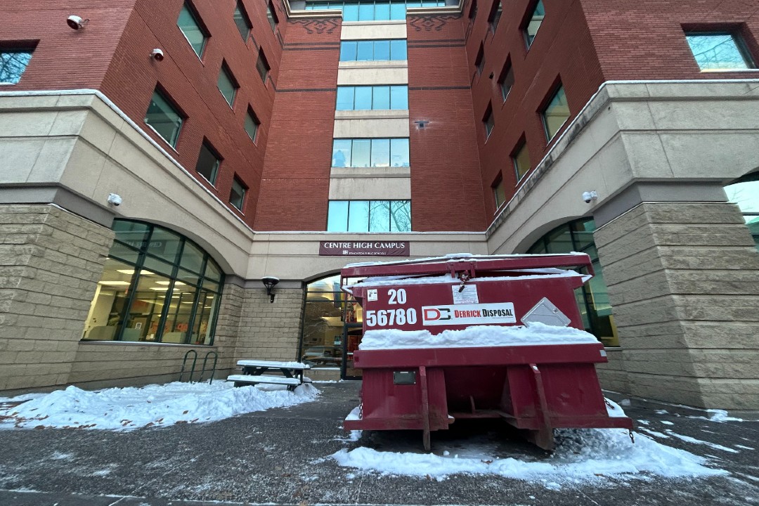 The west entrance to the Alberta College building has a sign reading "Centre High Campus" and is shown behind a large red dumpster.