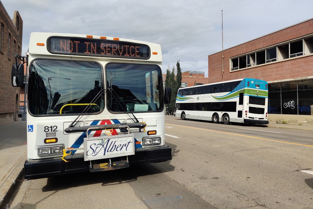 A St. Albert bus and a Strathcona County bus are parked on an Edmonton street.