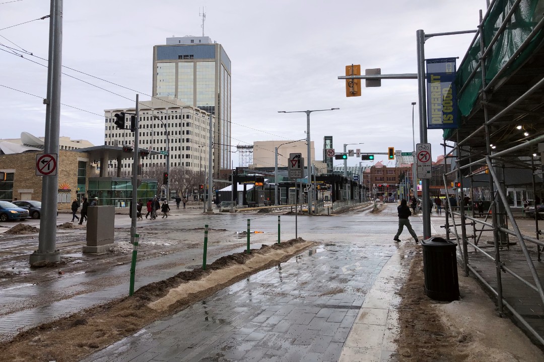 Pedestrians cross 100 Street and 102 Avenue, near the Stanley A. Milner Library in downtown Edmonton.