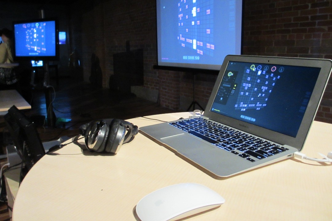 A computer, accessories, and digital artwork are displayed on three screens.