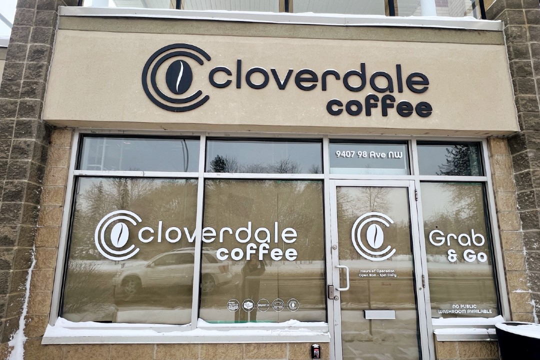 The exterior of Cloverdale Coffee, which includes a sign with its name and many QR codes.