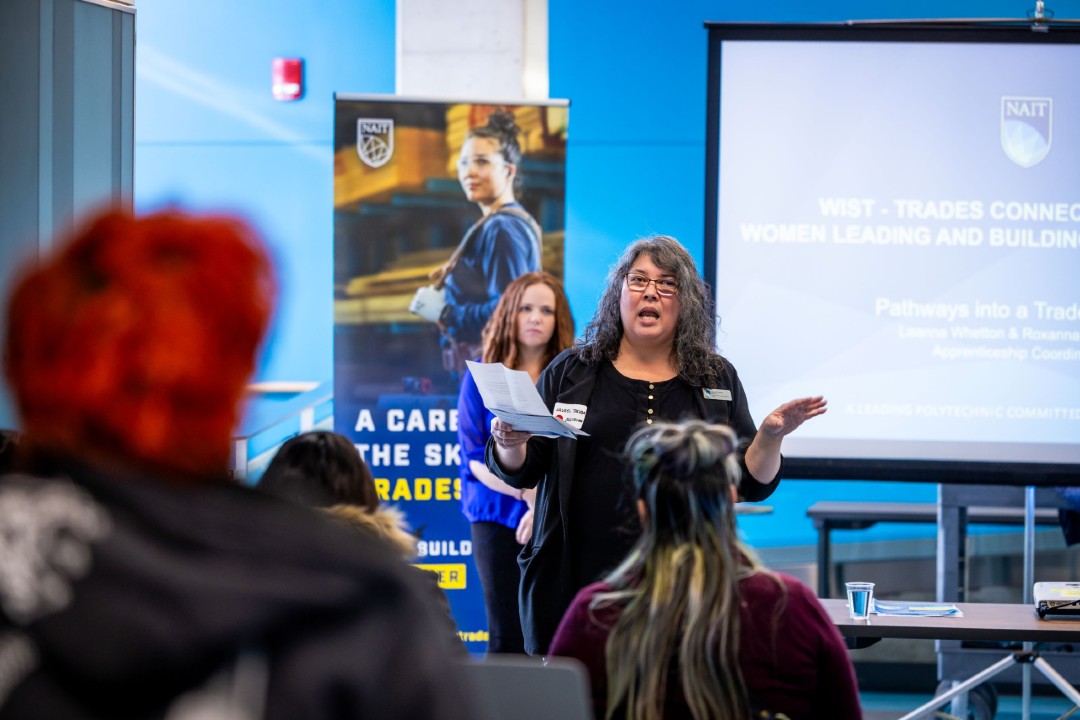 A presenter addresses NAIT students and prospective tradespeople during a Women in Skilled Trades networking event.