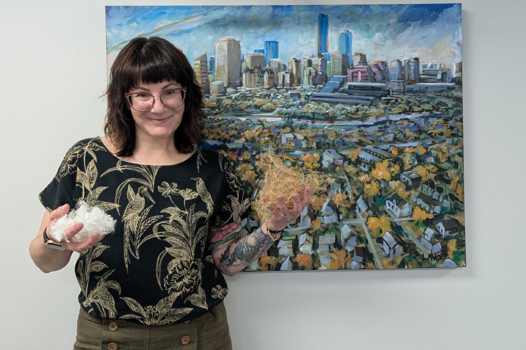 A smiling woman poses with two types of fibre made from hemp.