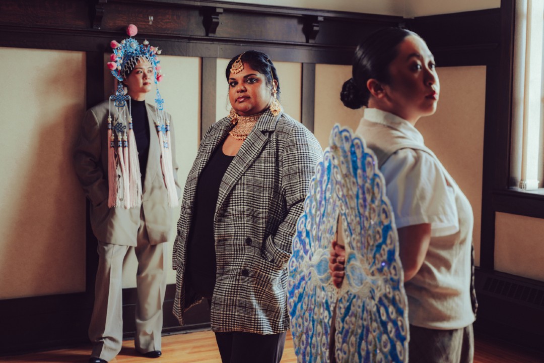 Artists explore what isn't in city archives Three artists pose in business clothing and colourful accessories.