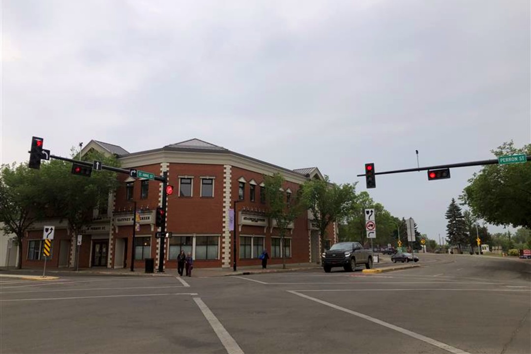 A truck and some people at an intersection in downtown St. Albert.