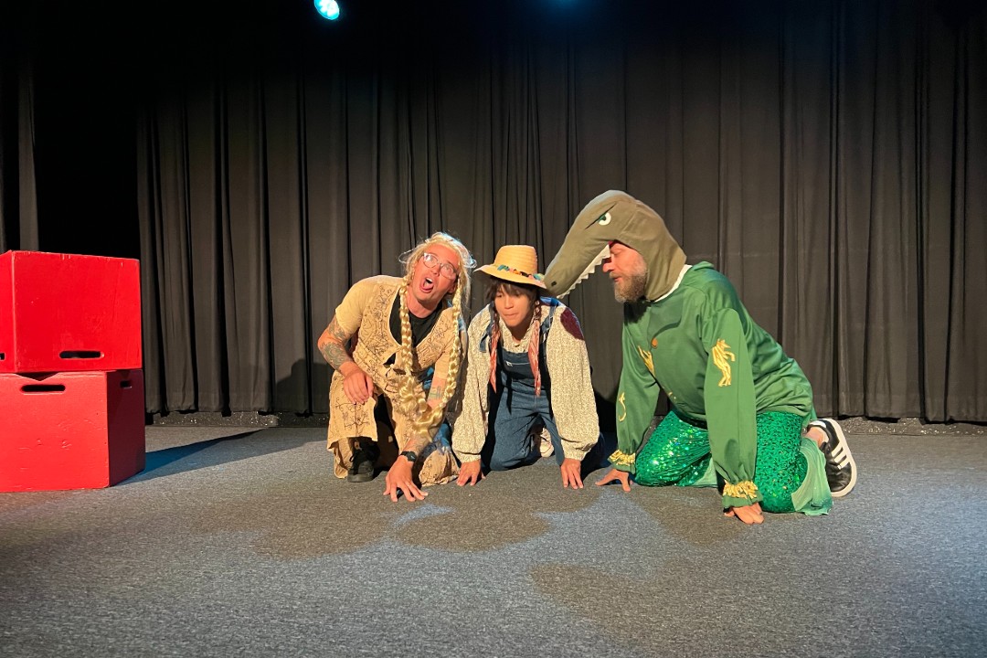 Three improvisers in costumes on a stage.