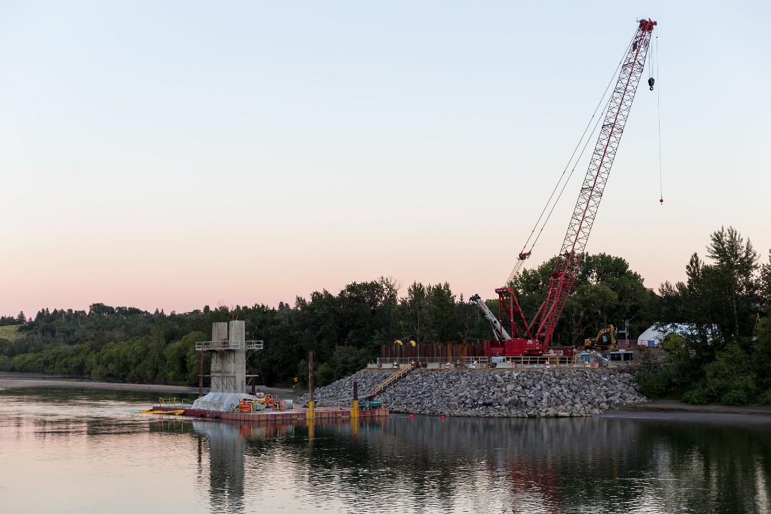 Noted: River valley plan, student housing, mayoral infill A crane sits atop rocks on the shore of Edmonton's river valley.