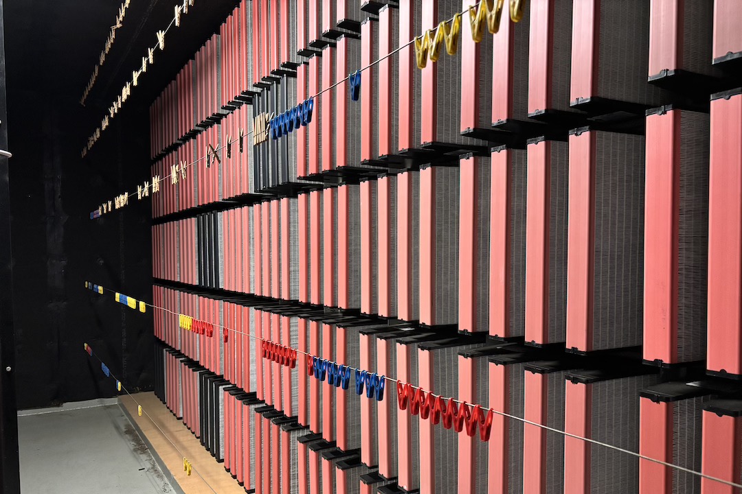 An industrial building air filtration room. There are four rows of filters, some with red caps and some with black caps.