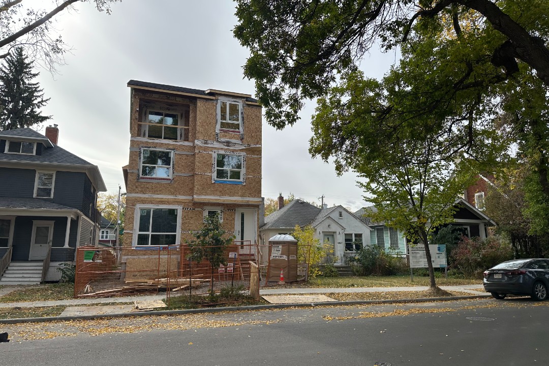 A home under construction next to an older home in Garneau