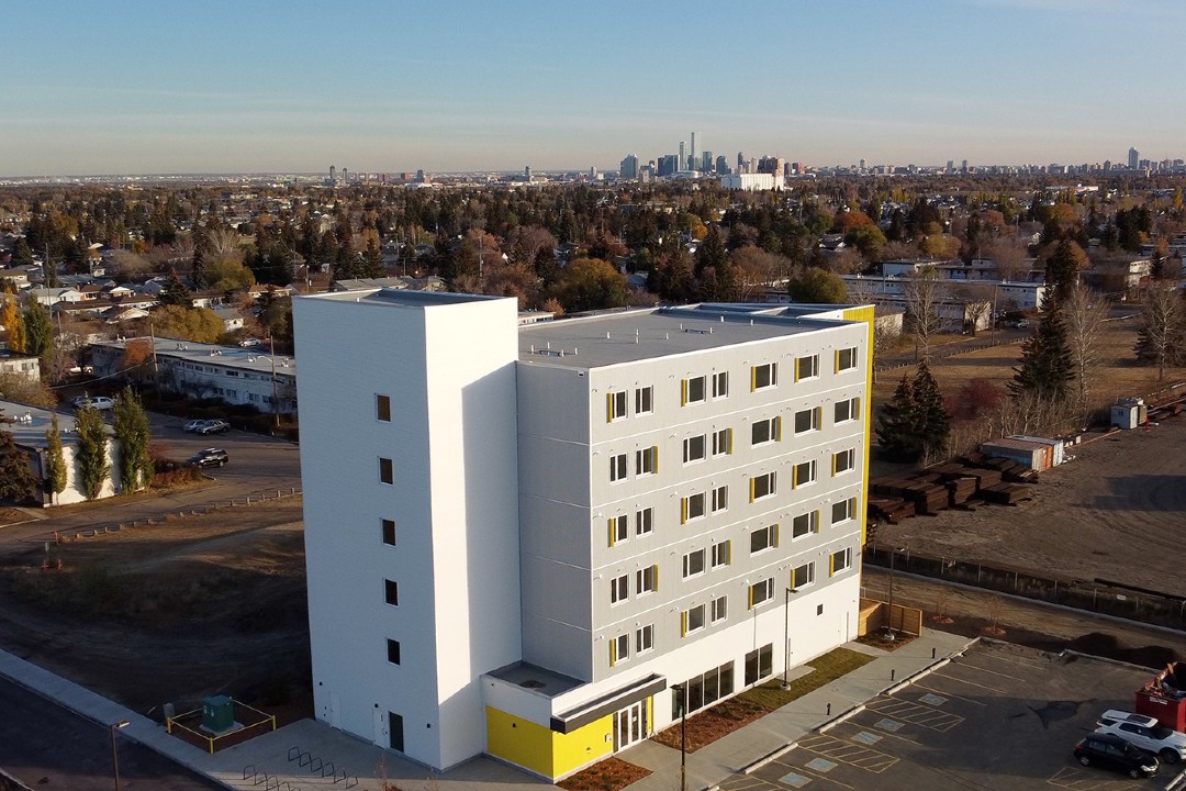 A photo of a white and yellow six-storey housing development.