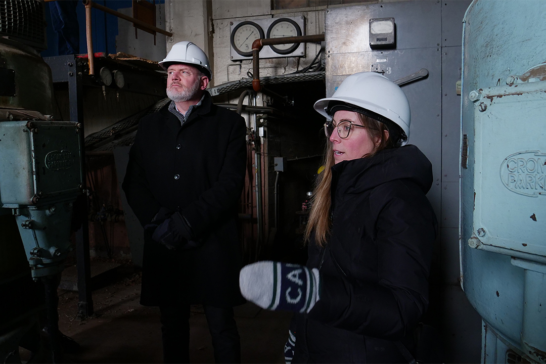 Avril McCalla and David Johnston in hard hats inside the plant