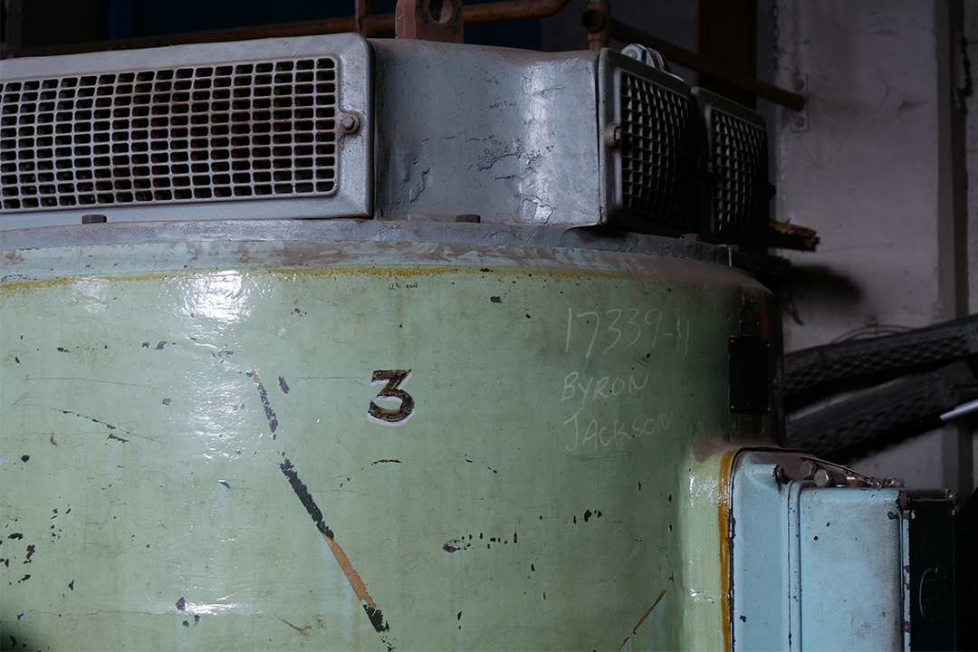 An old motor in the pump house with the number three painted on it