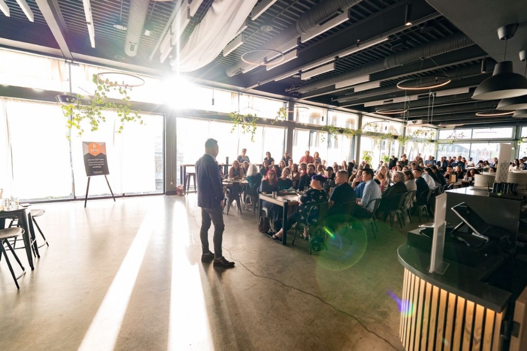 People gathered in an event space with sunlight pouring over them.
