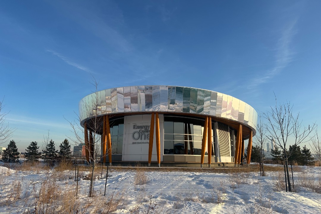 A building with a reflective roof in a snowy field.