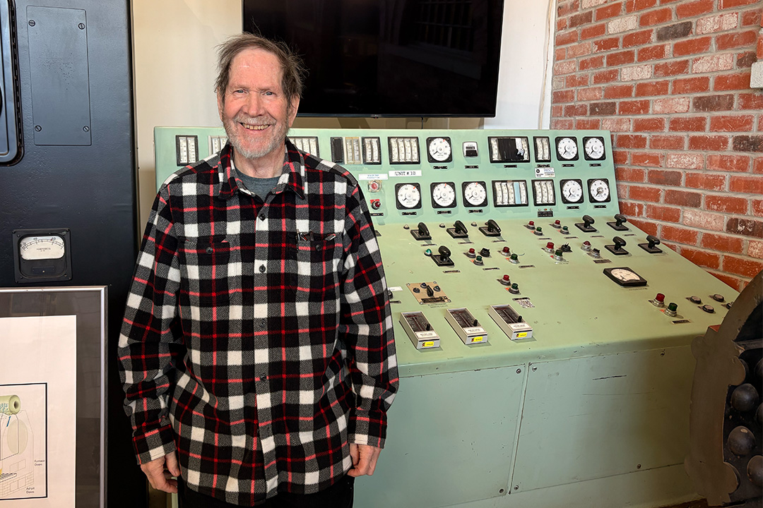 Paul Collis standing in front of a Rossdale power plant switch board