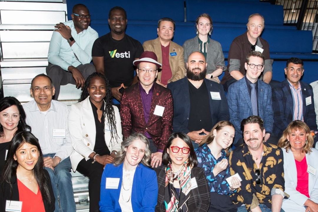 People seated in tiers inside an indoor space.