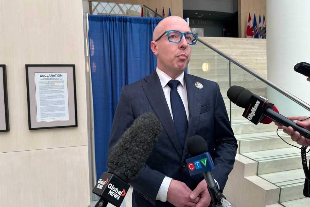 Mayor Andrew Knack speaks to an array of microphones