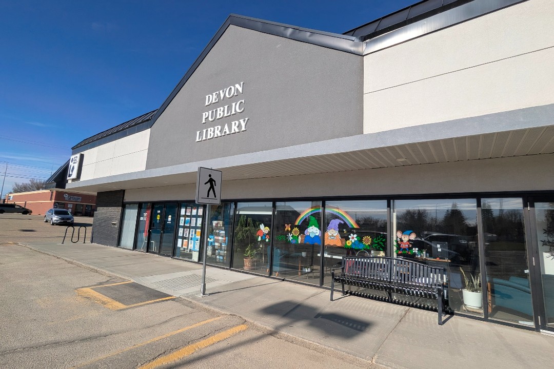 A grey library building in a strip mall.