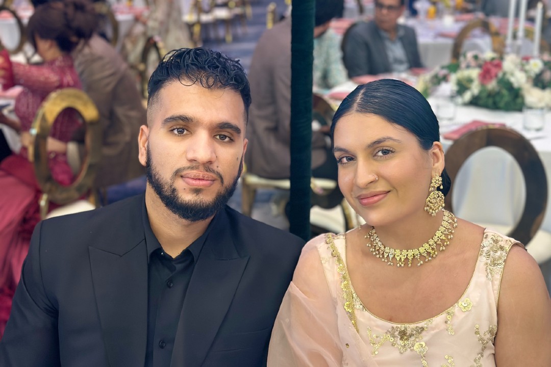 Two people in formal wear seated at a dinner table