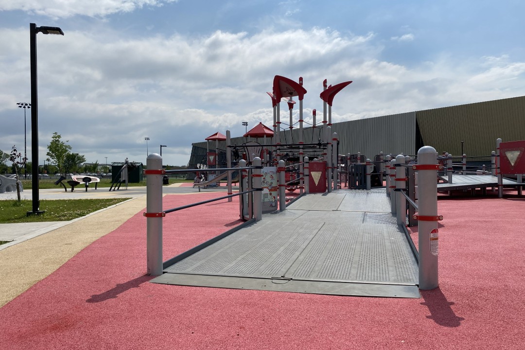 A playground with a wide, gently sloped ramp into the play area