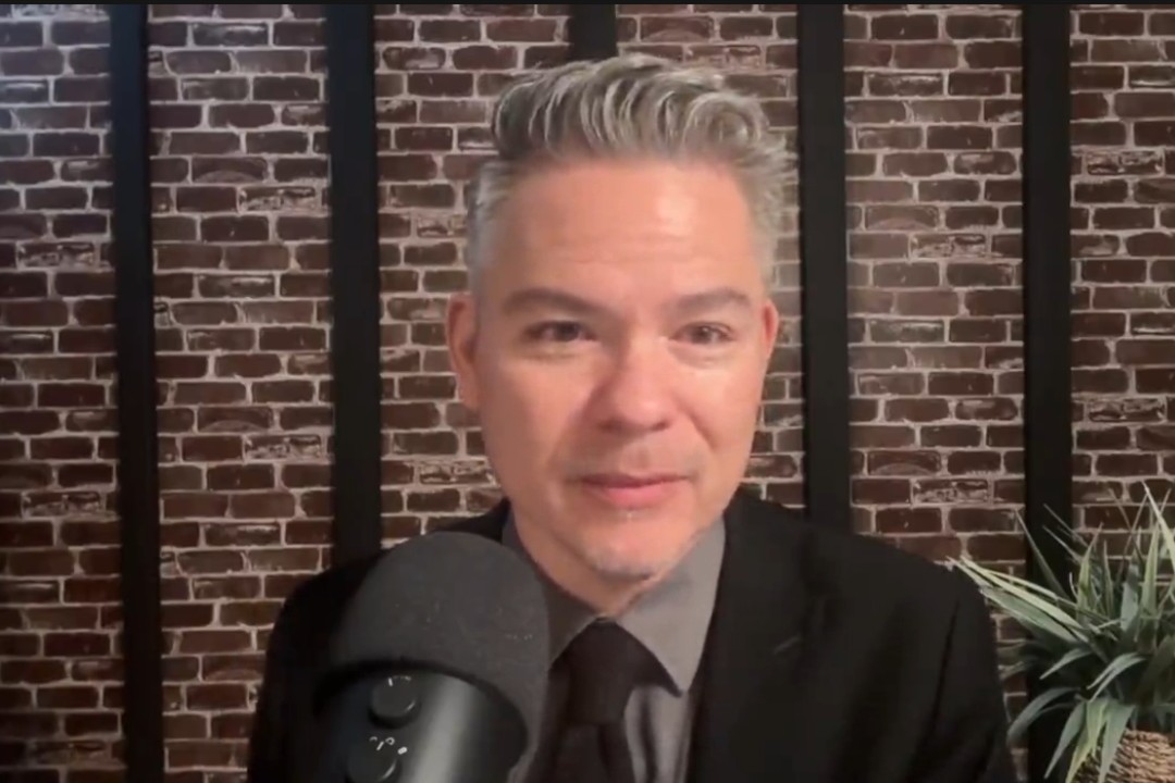 A screengrab of Coun. Aaron Paquette sitting at a microphone