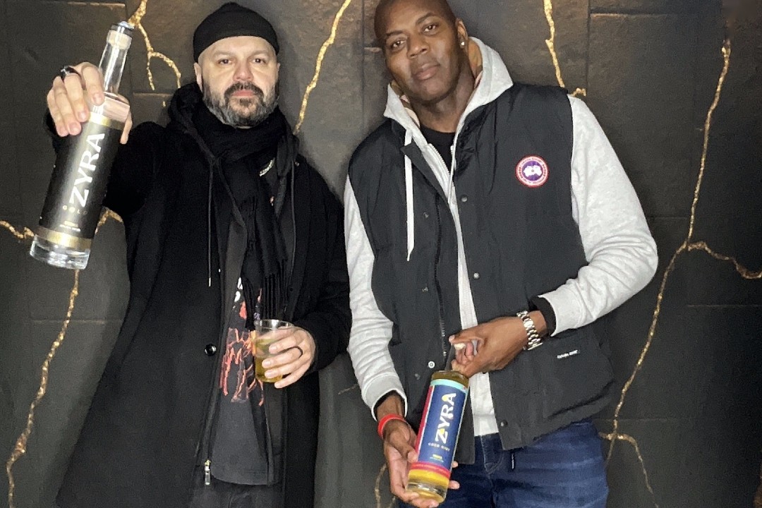 Two men pose with bottles of Zyra vodka