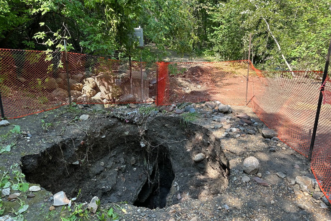 A sinkhole surrounded by orange fencing