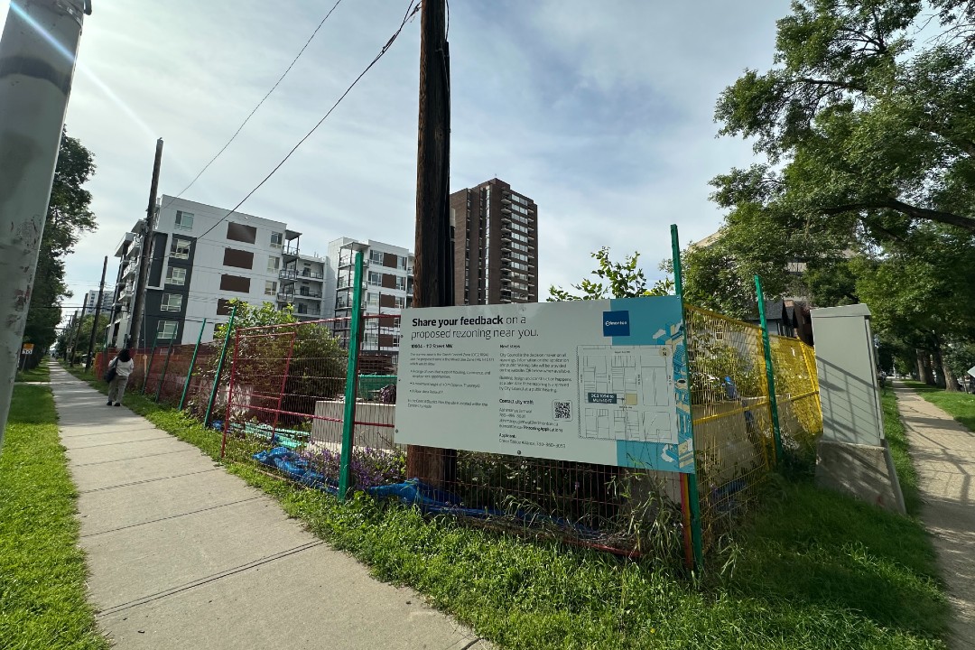 A rezoning sign in front of an empty lot