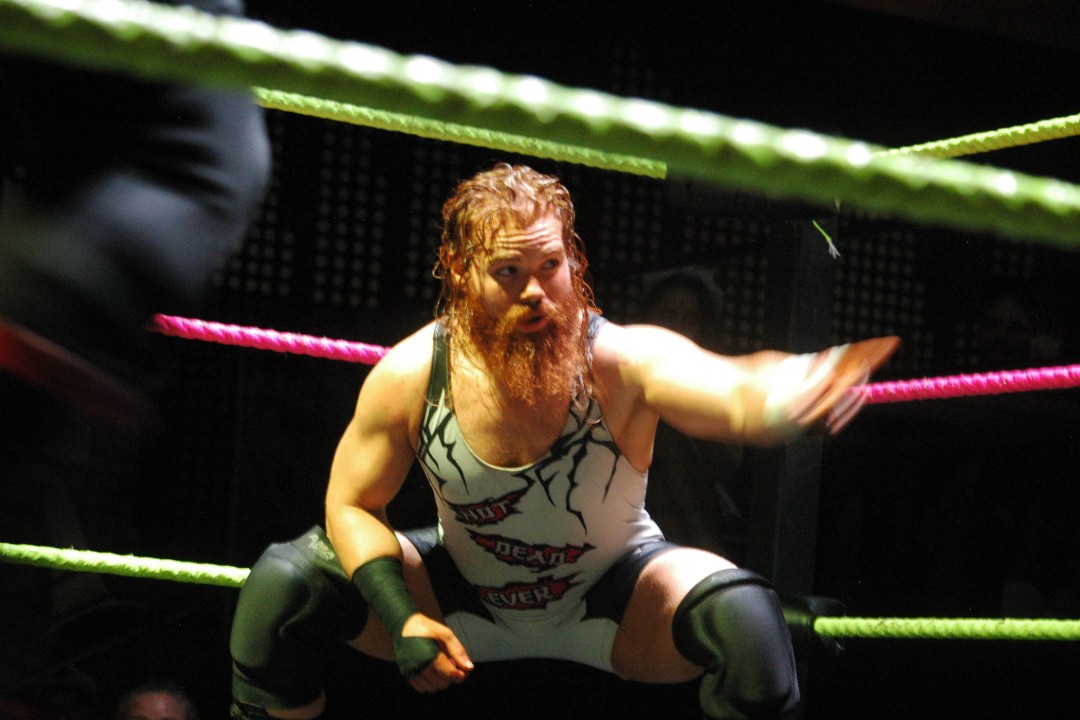 A bearded wrestler in the corner of a ring